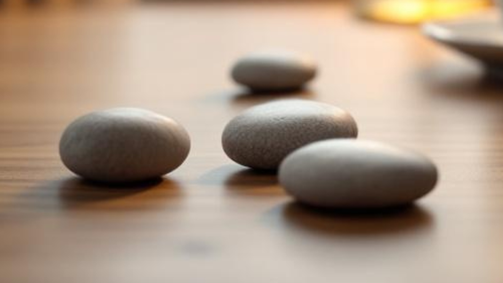Smooth stones beside a ceramic cup on a warm wooden tabletop, suggesting a clear choice between free and paid consultations.