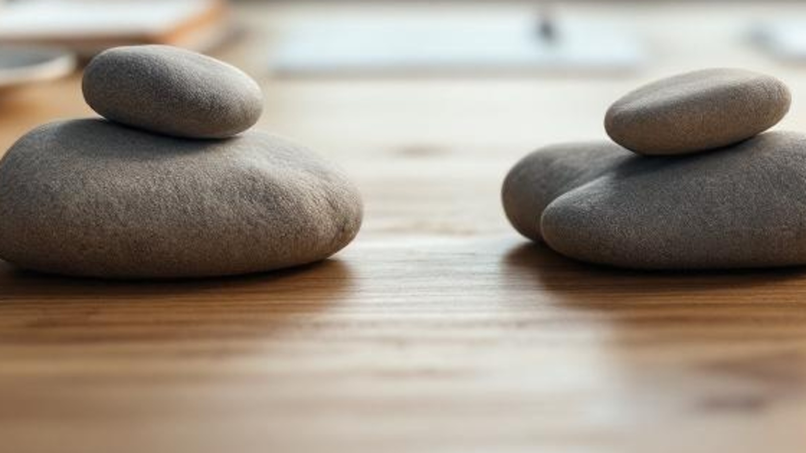 Close-up of smooth stacked stones on a warm wooden tabletop, symbolizing separate SEO paths for probate and estate planning.