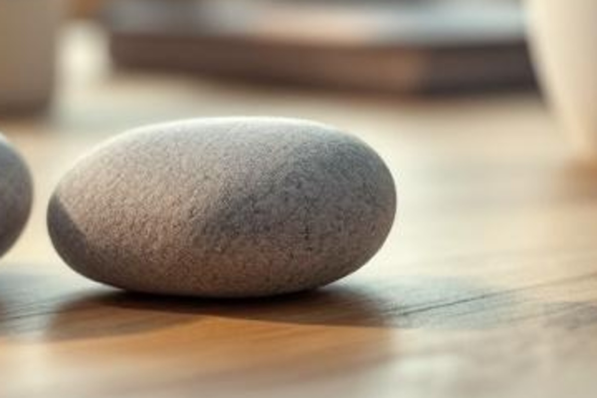 Single smooth stone on a warm wooden tabletop, suggesting a focused SEO path for a legal practice area